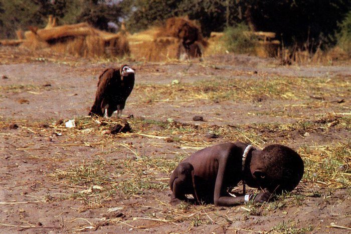 A vulture preying upon an emaciated Sudanese toddler near the village of Ayod